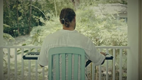 Un hombre con dos manos toca música en un instrumento de teclado