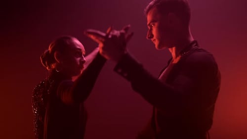 Danseurs exécutant une danse latine sur fond de lumière rouge