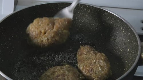 Nahaufnahme Die Fleischbällchen in der Pfanne drehen