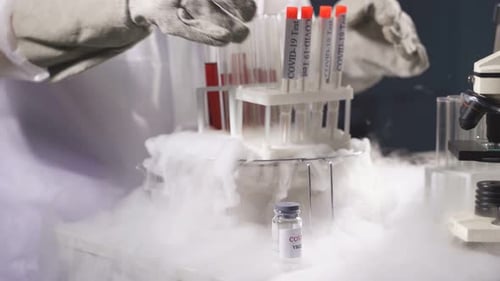 Scientist with Covid-19 Test Tubes and Vaccine in Lab