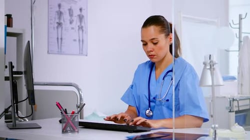 Medical Worker at Computer in Doctor's Office