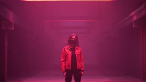 Dark Hallway with Lone Person Under Red Light