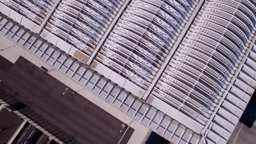 Drone shot of a architectural building used as bridge while cars and a transport train go underneath