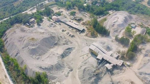 Aerial view of machine excavator trucks dig coal mining or ore with black grunge stone on ground