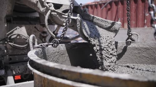 concrete is poured from a concrete mixer