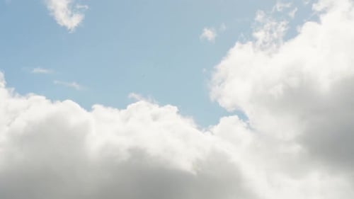 Vue en accéléré des nuages lumineux du ciel roulant sur le ciel bleu, la lumière du soleil
