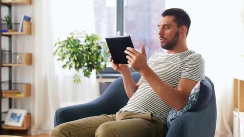 Man Video Calling Using Tablet in Bright Living Room