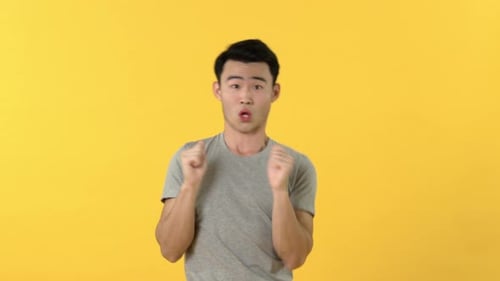 Young Adult Dances in Front of Yellow Backdrop