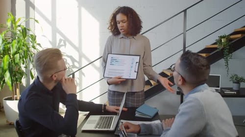 Colleagues Analyzing Company Statistics Together