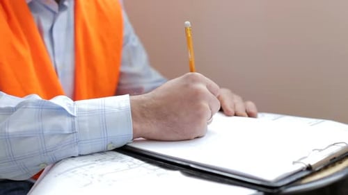Construction engineer works with blueprints in the office.