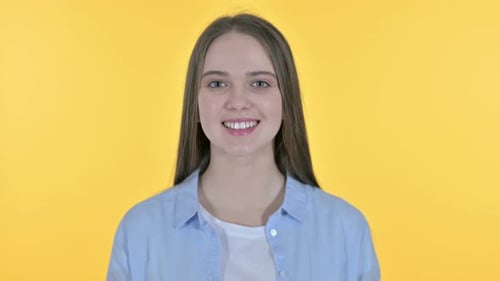 Smiling Young Woman Portrait on Yellow Background