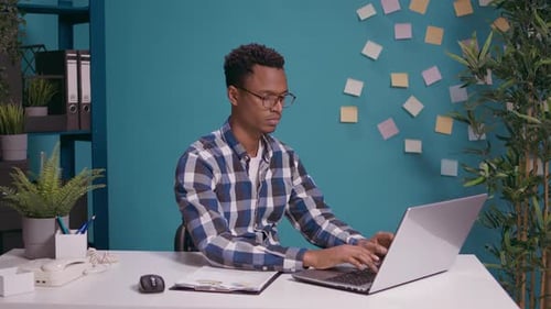 Young Adult Working at Desk in Bright Office