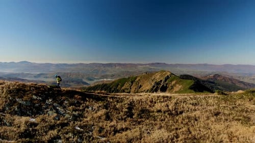 Aerial Slider Shot Man Walking on Mountain Ridge at Sunrise