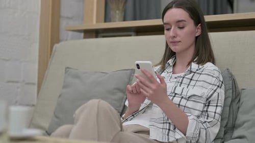 Young Woman Using a Smartphone on the Couch