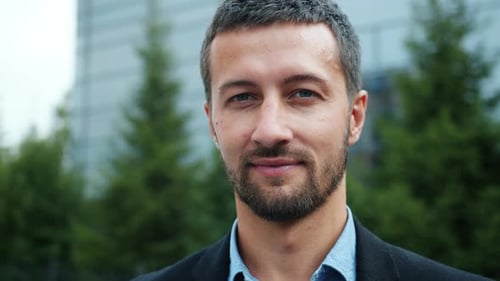 Portrait rapproché au Ralenti d'un entrepreneur masculin souriant à l'extérieur dans une rue de la ville