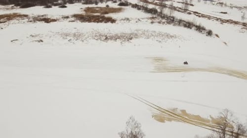 ATV Rider on Snow-Covered Field, Aerial
