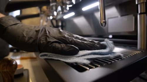 Gloved Hand Cleaning Espresso Machine with Cloth