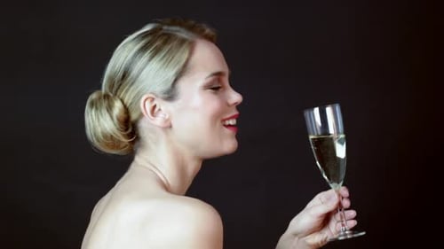 Beautiful young woman toasting and drinking champagne