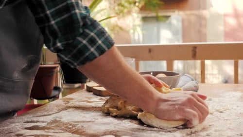 Man Kneading Dough on Floured Surface