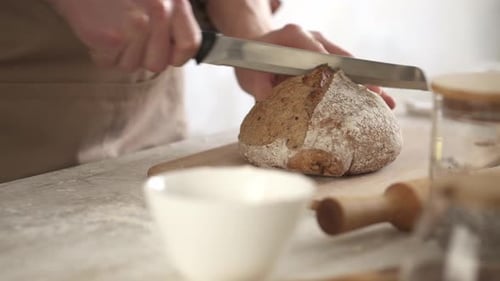 Adult Slicing Bread Loaf in Kitchen