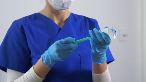 Doktor in Gesichtsmaske mit Spritze und Medizin