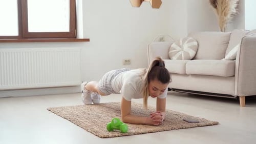 Woman Holds Elbow Plank in Bright Living Room