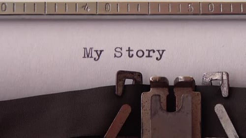 Typing phrase My Story on retro typewriter. Close up.