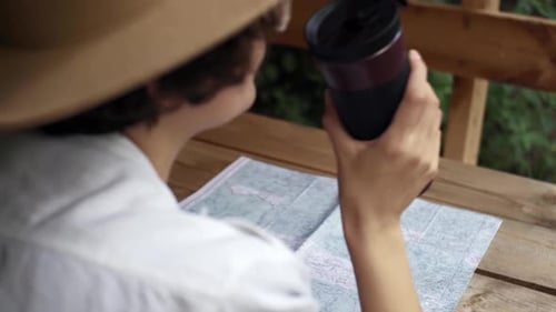 Traveler Studies Map with Binoculars Made From Mug