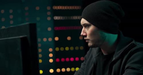 Man In Beanie Using Computer At Night