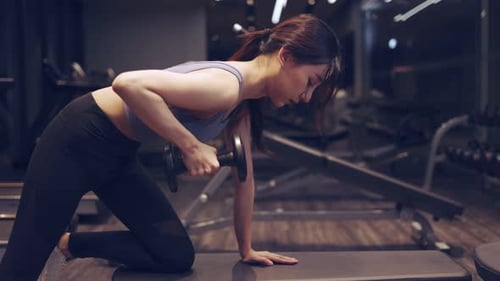 Asian young Female hands taking bodybuilding dumbbells in gym club