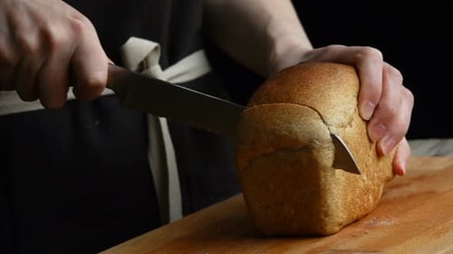 Slicing Brown Bread on a Wooden Board