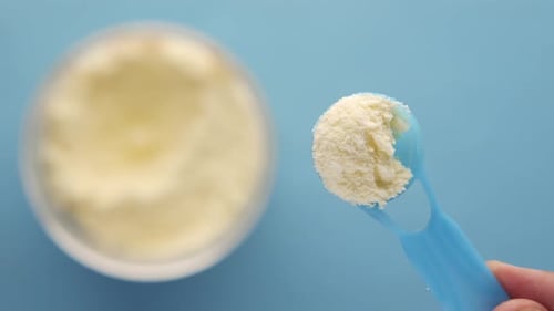Close Up of Baby Milk Powder and Spoon on Tile Background