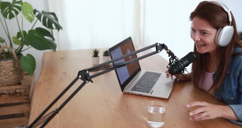 Woman Talking Into Microphone and Using Laptop