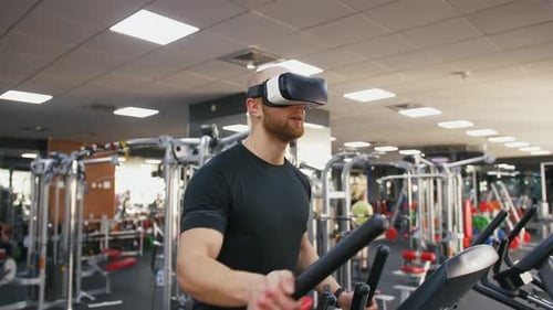 Young Strong Man Exercising on Treadmill at the Gym Wearing VR Glasses