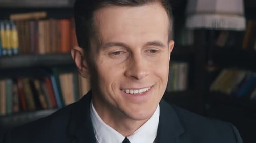 Nahaufnahme eines glücklichen Geschäftsmannes im Anzug mit Blick in die Kamera im Büro Positiver männlicher Mitarbeiter