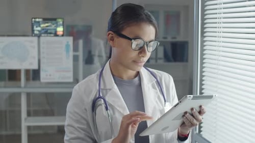 Female Doctor Uses Tablet in Modern Hospital