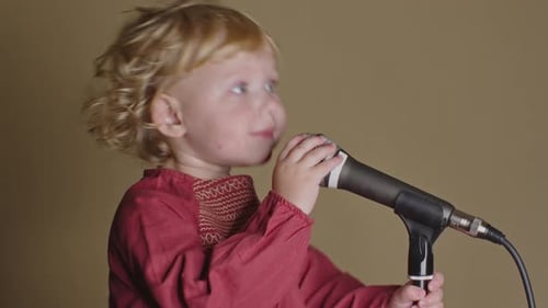 Child Sings into Microphone on Stand Close Up