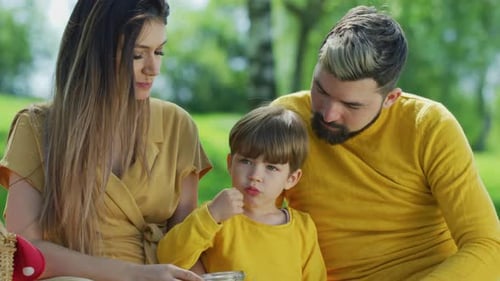 Happy Family Eating Together at Outdoor Picnic