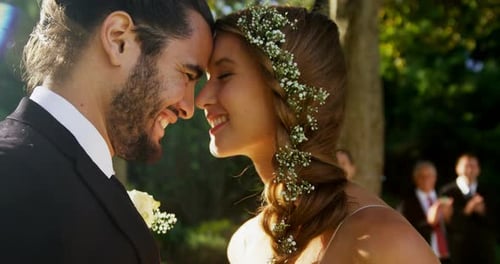 Bride and groom embracing and guests clapping In background 4K