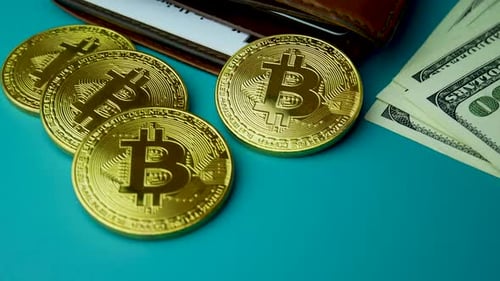 Pièces BTC Bitcoin en or sur des billets de 100 dollars
