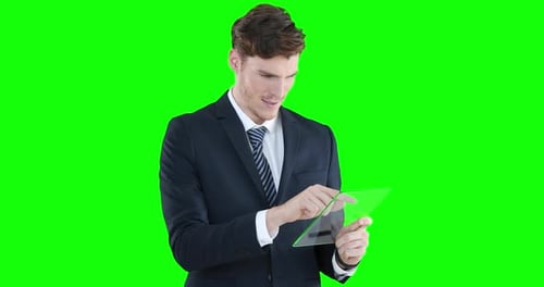 Caucasian man holding a transparent screen on green background