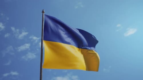 Realistic Ukrainian Flag Waving Against Blue Sky