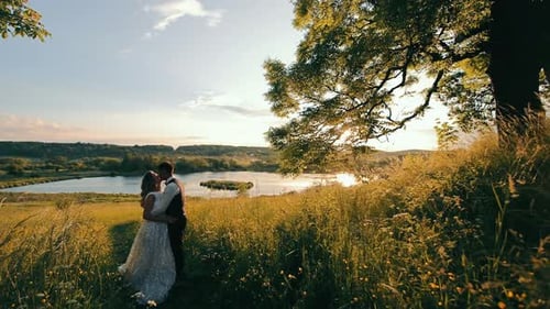 A Happy Young Couple Spends an Hour at the Lake at Sundown