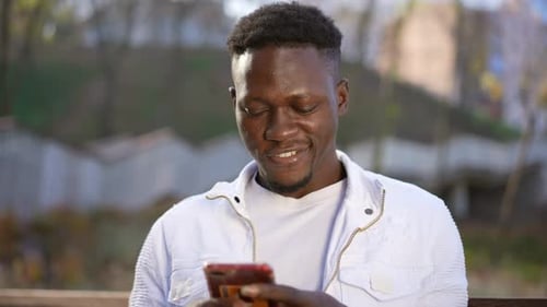 Young Man Uses Phone Outside in Urban Setting