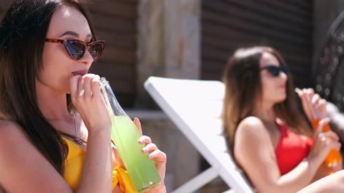 Two Girls Laying Out By the Pool