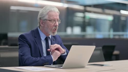 Senior Man Working on Laptop in Office