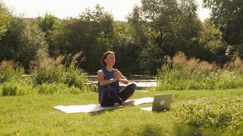 Woman Practicing Yoga in a Grassy Park
