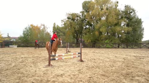 Two Young Women Riding Horses on Training Ground