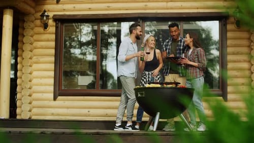 Friends Enjoying Barbecue at Rural Log Cabin