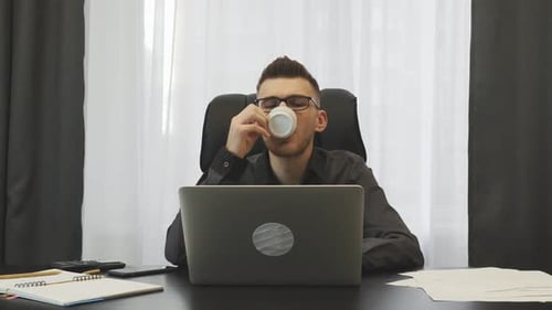 Erfolgreicher Geschäftsmann trinkt Kaffee in seinem modernen Büro. Business-Konzept